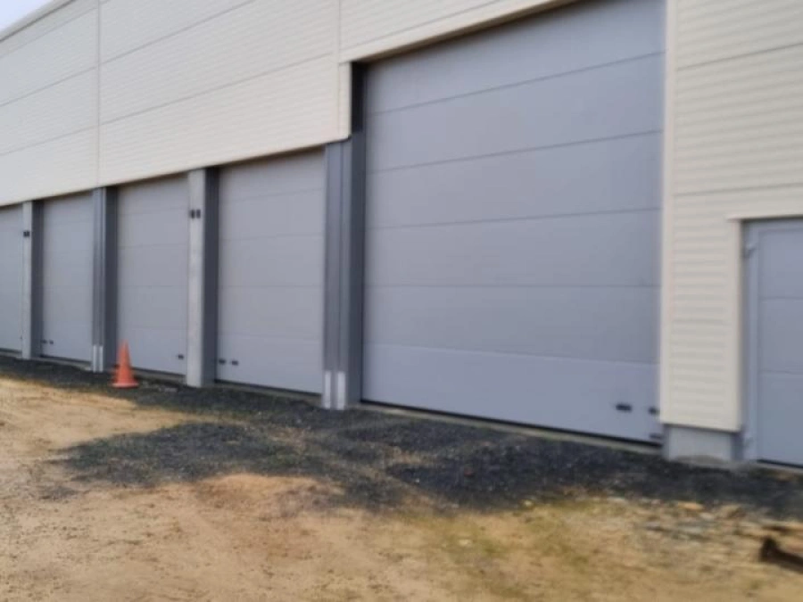 Rangée de portes sectionnelles grises Hormann pour box professionnels, installation AFC dans le Calvados