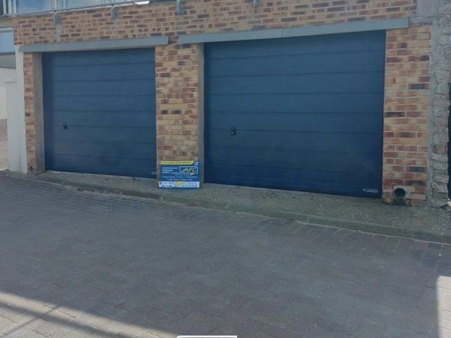 Deux portes de garage sectionnelles anthracite sur façade brique, devanture maison Calvados par AFC