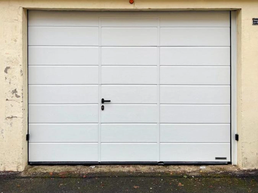 Porte de garage sectionnelle blanche Hörmann avec portillon intégré, façade pierre, AFC Caen