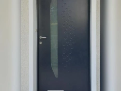 Porte d'entrée anthracite à motif bulles et oculus dépoli, design contemporain posé par AFC